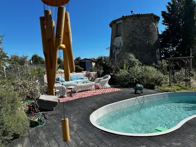 a hot tub in a yard with a castle in the background at Moulin du Sud in Lafage