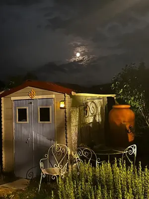 a tiny house with a vase and two chairs in front at Moulin du Sud in Lafage