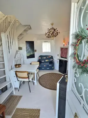 a living room with a staircase and a table and chairs at Moulin du Sud in Lafage