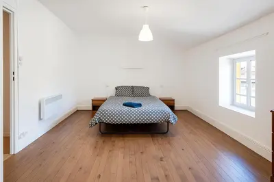 a bedroom with a bed in the middle of a room at Appartement 2 chambres avec baignoire Lavelanet in Lavelanet