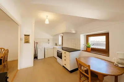 a kitchen with a wooden table and a dining room at Appartement 2 chambres avec baignoire Lavelanet in Lavelanet