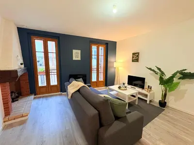 a living room with a couch and a tv at L'Écho du Castella in Pamiers