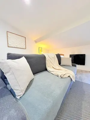 a living room with a couch with a blanket on it at Le Refuge du Midi in Pamiers