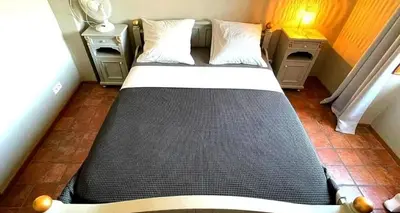 a bed in a small room with two night stands at Le Beau Coin in Serviès-en-Val