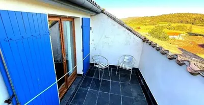 a balcony with two chairs on a house at Le Beau Coin in Serviès-en-Val