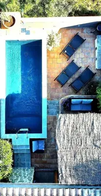 a water fountain in front of a brick building at Le Beau Coin in Serviès-en-Val
