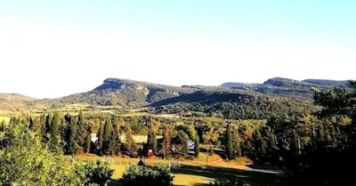a forest of trees with mountains in the background at Le Beau Coin in Serviès-en-Val
