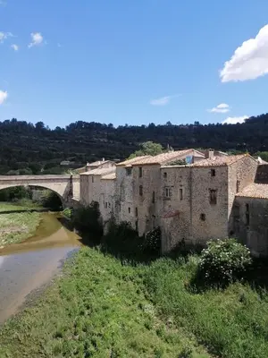 an old building next to a river with a bridge at Le Beau Coin in Serviès-en-Val