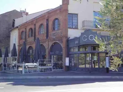 a large brick building with a restaurant on the street at Maison de ville Centre de Narbonne 3 moulins in Narbonne