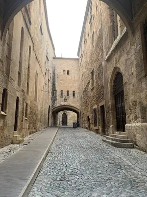 an alley in an old building with an archway at Maison de ville Centre de Narbonne 3 moulins in Narbonne