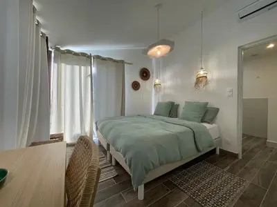 a bedroom with a bed with green sheets and a window at Villa avec piscine privée - Capestang in Capestang