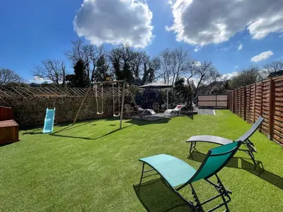 a yard with a playground with two chairs and a swing at Évasion ensoleillée avec jacuzzi à Cazedarnes in Cazedarnes