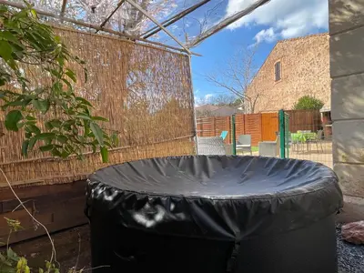 a large black trash can in a garden at Évasion ensoleillée avec jacuzzi à Cazedarnes in Cazedarnes