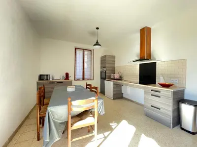 a kitchen and dining room with a table and chairs at Évasion ensoleillée avec jacuzzi à Cazedarnes in Cazedarnes