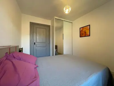 a bedroom with a large bed with pink sheets at Évasion ensoleillée avec jacuzzi à Cazedarnes in Cazedarnes
