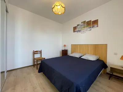 a bedroom with a blue bed and a chair at Évasion ensoleillée avec jacuzzi à Cazedarnes in Cazedarnes