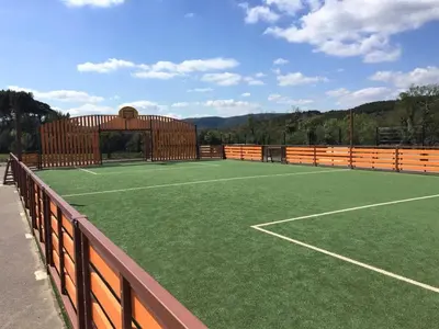 an artificial tennis court with a fence and a tennis court at La Maison Des Vendangeurs in Villesèque-des-Corbières