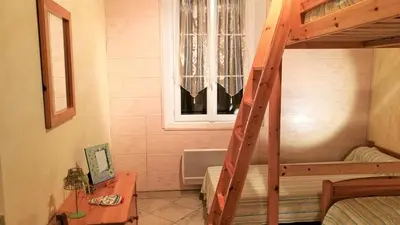 a bedroom with a bunk bed and a window at La Maison Des Vendangeurs in Villesèque-des-Corbières