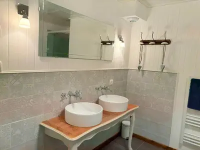 a bathroom with two sinks and a mirror at Las Coumeilles in Leychert