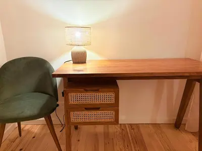 a desk with a lamp and a green chair at Las Coumeilles in Leychert