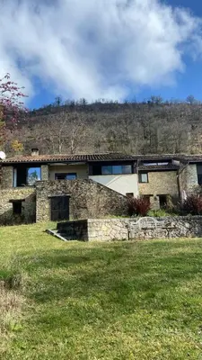a stone house with a stone wall in a field at Las Coumeilles in Leychert