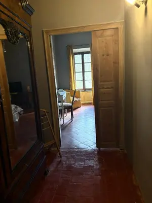 a hallway with a door and a mirror and a table at O'MAZETTE CHAMBRE ROMANTIQUE VUE JARDIN AVEC PISCINE découverte de l'Aude in Fabrezan