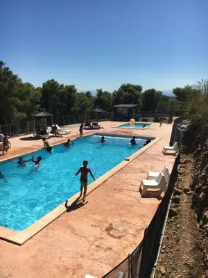 a group of people in a swimming pool at Camping Le Bois De Pins in Salses-le-Chateau