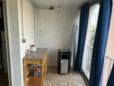 a room with a refrigerator and a table and a window at Appart Gwen in Gruissan