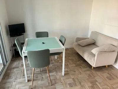 a room with a table and chairs and a couch at Appart Gwen in Gruissan