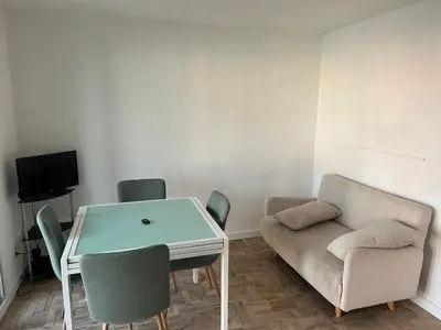a living room with a couch and a table and chairs at Appart Gwen in Gruissan