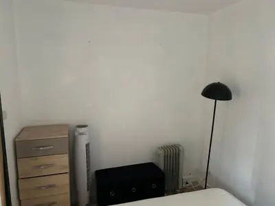 a bedroom with a bed and a lamp and a dresser at Appart Gwen in Gruissan