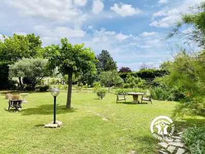 a park with benches and a lamp in the grass at Au bien-etre in Villemoustaussou