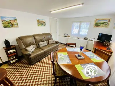 a living room with a table and a couch at Au bien-etre in Villemoustaussou