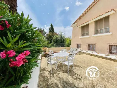 a patio with a table and chairs and flowers at Au bien-etre in Villemoustaussou
