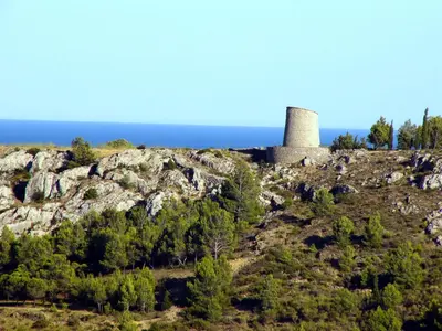 a tower on a hill with the ocean in the background at Maison tout confort belle terrasse sud in Sigean