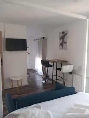 a living room with a bed and a table and chairs at White and Cotton Suite in Saint-Paul-de-Fenouillet