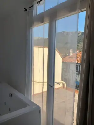 a bathroom window with a view of a balcony at White and Cotton Suite in Saint-Paul-de-Fenouillet
