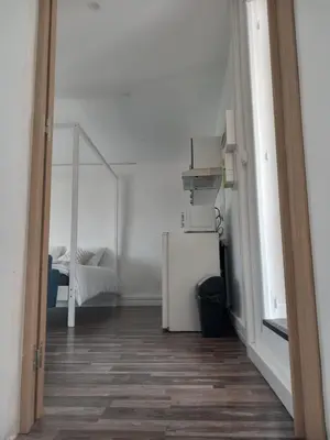 a room with a white refrigerator and a bedroom at White and Cotton Suite in Saint-Paul-de-Fenouillet