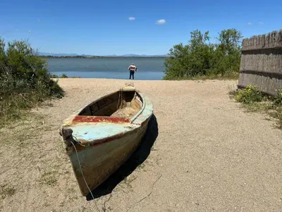 a boat sitting on the beach with a man in the background at Suite Noire et Blanche in Saint-Paul-de-Fenouillet