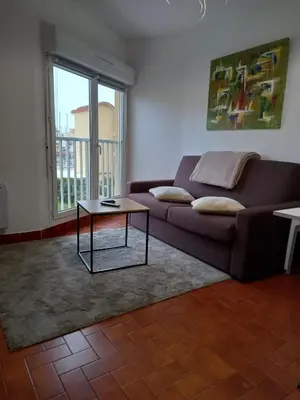 a living room with a couch and a table at T2 standing Gruissan in Gruissan
