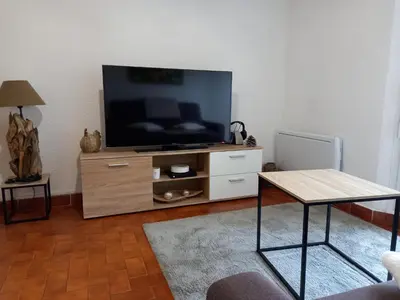 a living room with a flat screen tv on a wooden entertainment center at T2 standing Gruissan in Gruissan