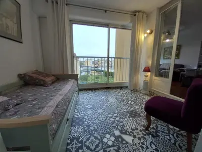 a bedroom with a bed and a balcony with a view at T2 standing Gruissan in Gruissan