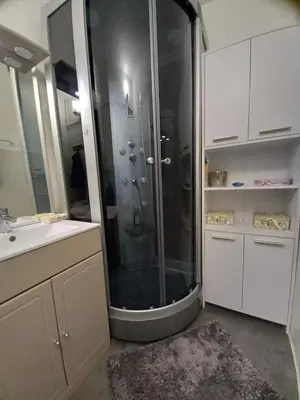 a bathroom with a shower with a sink and a mirror at T2 standing Gruissan in Gruissan
