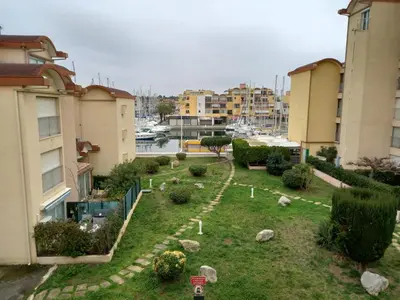 a garden with rocks in the grass between two buildings at T2 standing Gruissan in Gruissan