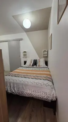 a bedroom with a bed in a white room at Le petit cocon centre ville in Tuchan