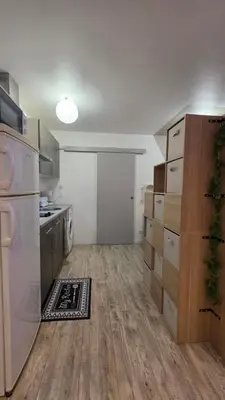 a kitchen with white appliances and wooden floors at Le petit cocon centre ville in Tuchan