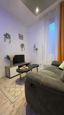 a living room with a couch and a table at Le petit cocon centre ville in Tuchan