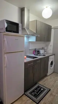 a kitchen with a white refrigerator and a dishwasher at Le petit cocon centre ville in Tuchan