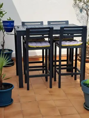 a black dining table and two chairs with plants at gruissan la belle rive droite in Gruissan