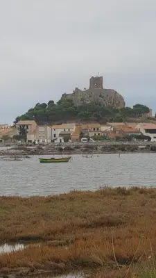 a boat in the water with a castle in the background at gruissan la belle rive droite in Gruissan